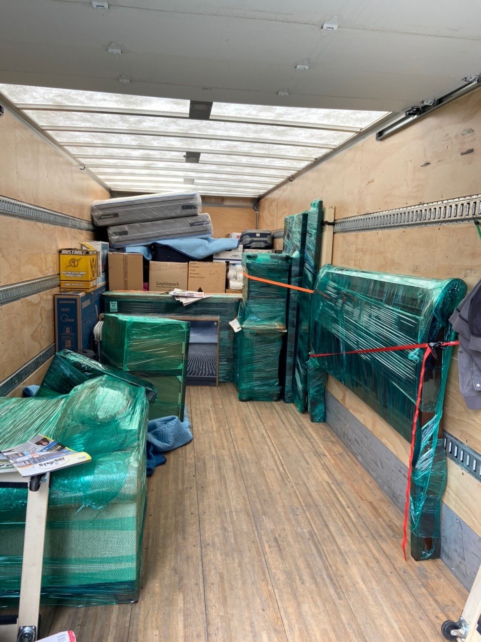 Moving truck interior packed with wrapped furniture